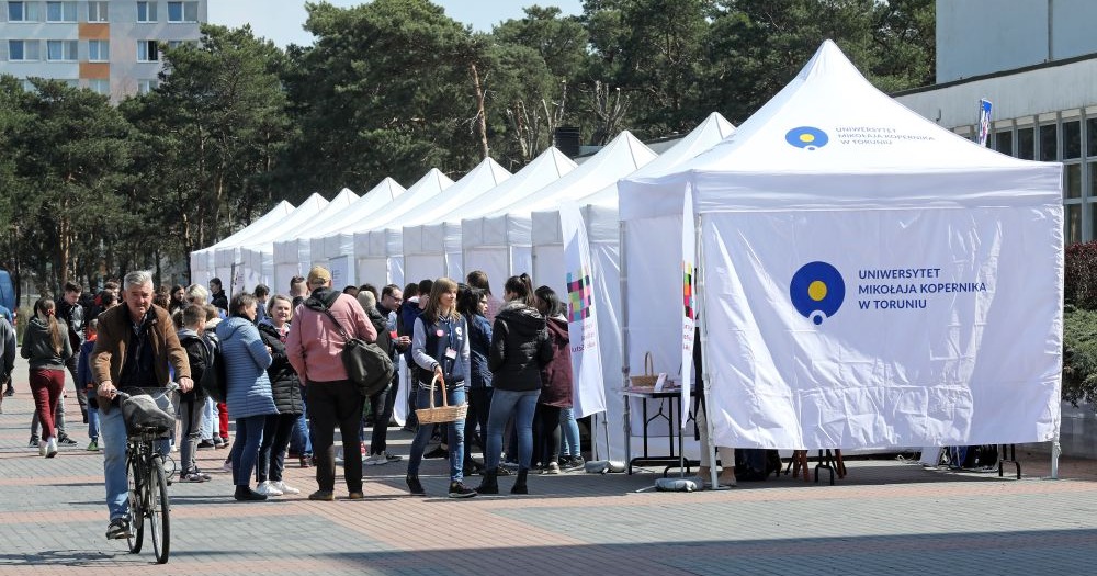 Na zdjęciu widać stanowiska, na których odbywają się warsztaty i pokazy. Przed nimi stoi wiele osób - uczestników