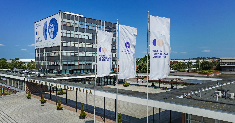 The Nicolaus Copernicus University Rectorate with a banner promoting the World Copernican Congress and 3 flags with Congress symbols.