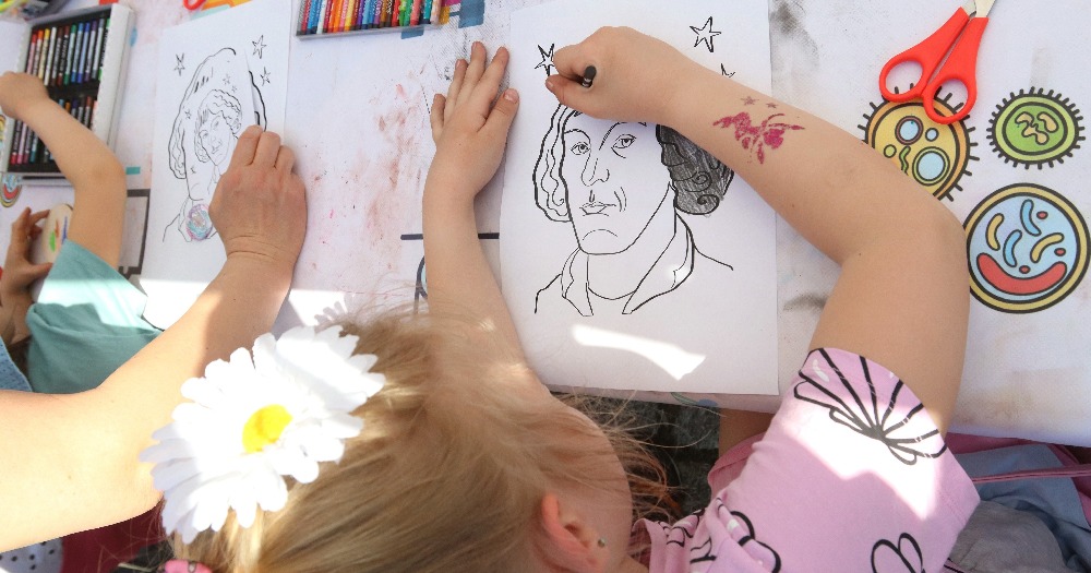 Zdjęcie dzieci kolorujących kolorowanki z podobizną Mikołaja Kopernika.