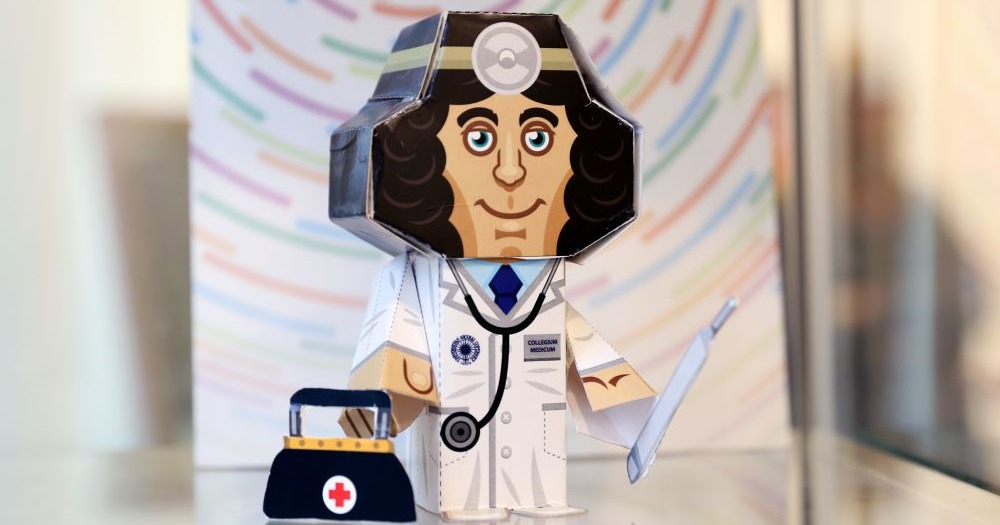 Papierowa figurka Mikołaja Kopernika jako lekarza (w lekarskim kitlu, ze stetoskopem)